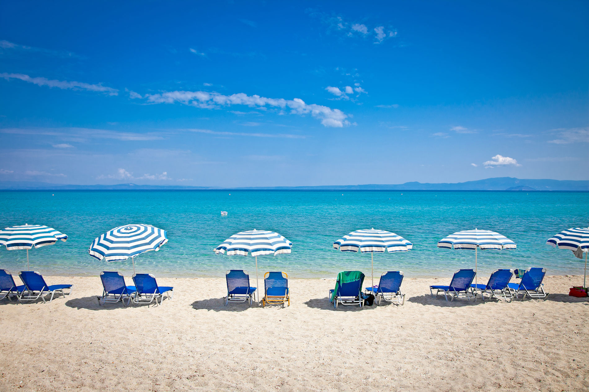 row of beach chairs on beach